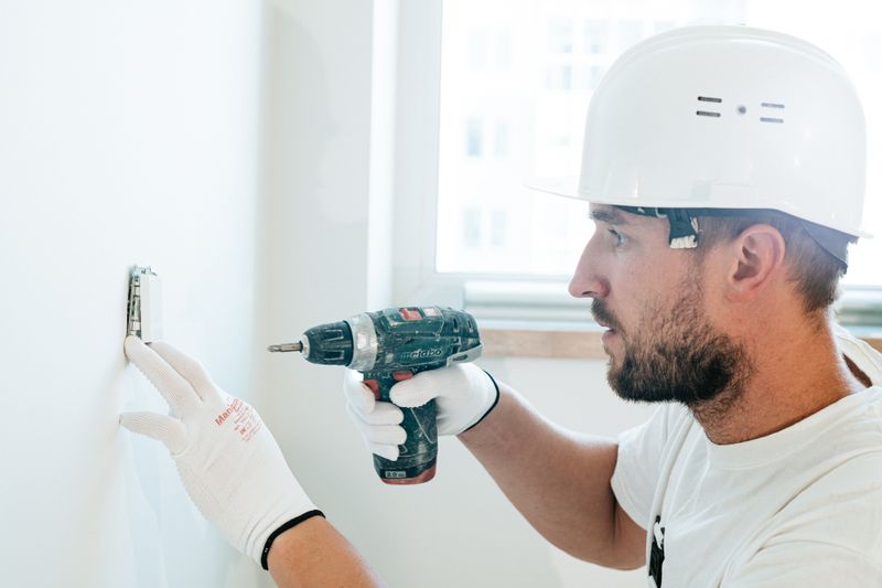 a man drilling a hole on the wall